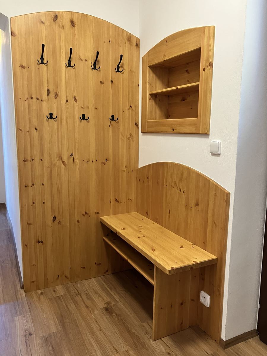 Předsíň s dřevěným obkladem, věšáky a lavicí